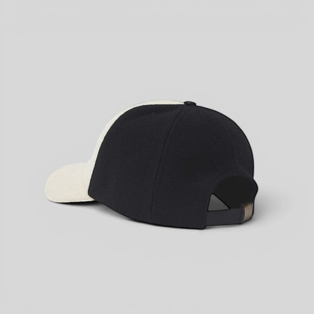 Baabuk Blacknose wool baseball cap in black and white with an adjustable leather strap, rear view.