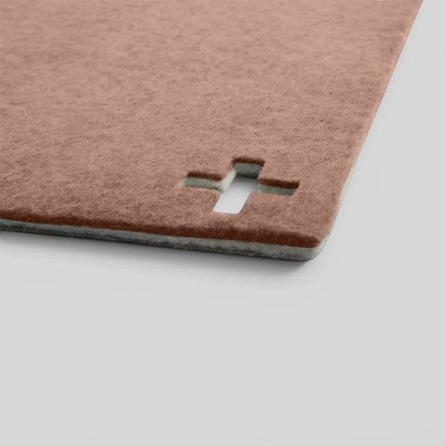 Baabuk brown felted wool table mat with a Swiss cross cutout detail, handmade from natural New Zealand wool.