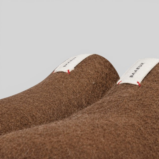 Baabuk brown wool Kanga slippers featuring a white branded fabric tag on a neutral background