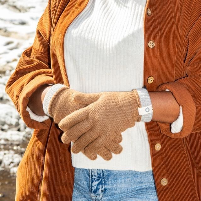 Baabuk camel baby alpaca wool gloves with grey cuffs worn by a person in a corduroy shirt