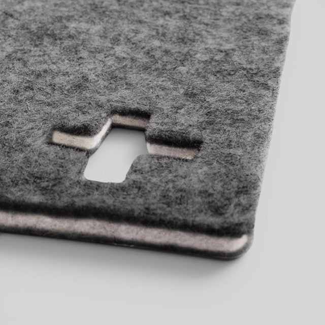 Baabuk dark grey felted wool table mat with a Swiss cross cutout design made from natural New Zealand sheep wool.