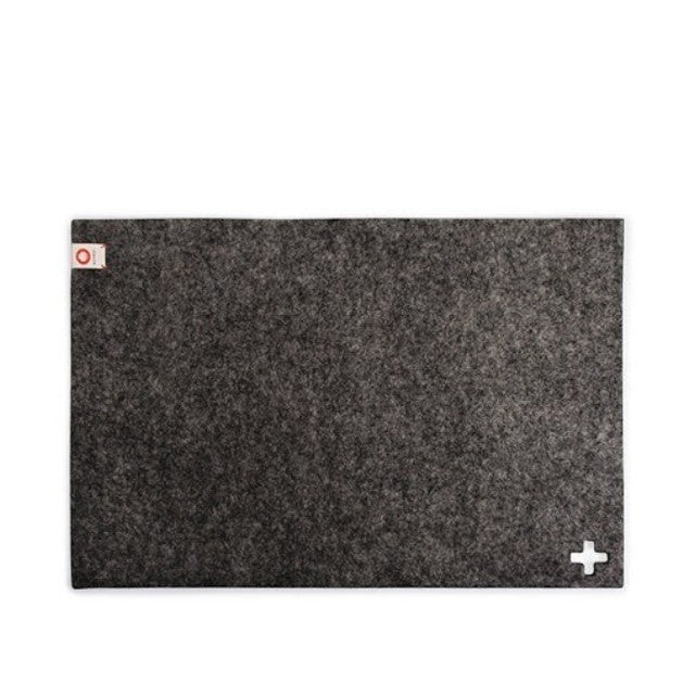 Baabuk dark grey rectangular felted wool table mat with a small Swiss cross detail and brand tag.