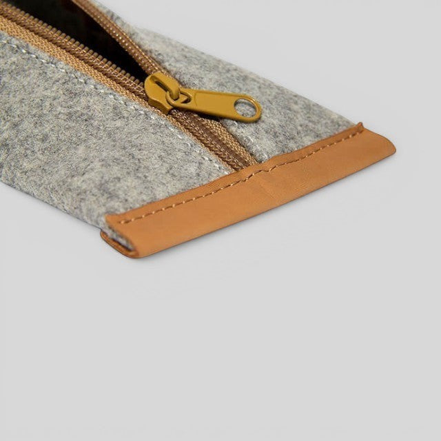 Baabuk grey wool pencil case with brown leather trim and a mustard yellow zipper closure.