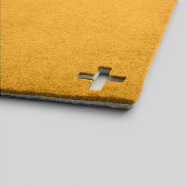 Baabuk honey yellow felted wool table mat with a Swiss cross cutout detail, handmade from New Zealand wool.