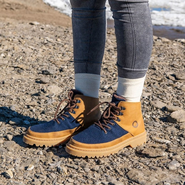 Baabuk Ice Wooler navy and brown wool boots with nubuck leather details worn outdoors on a rocky path.