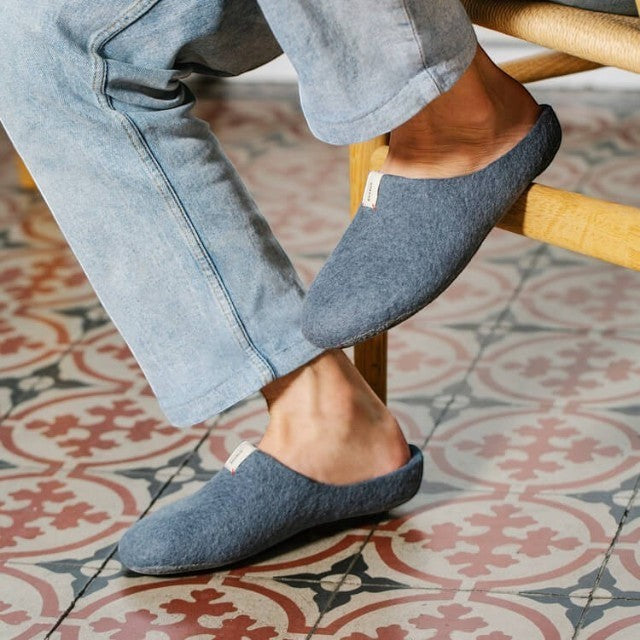 Baabuk Kanga grey wool slippers worn by a person in light blue jeans, featuring a minimalist slip-on design.