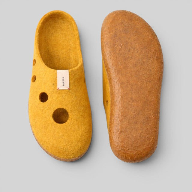 Baabuk Kanga slippers in yellow wool with Swiss cheese hole design and latex soles, viewed from top and bottom.