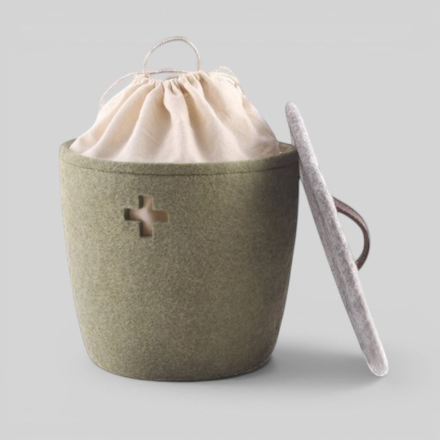 Baabuk small khaki felted wool basket with a Swiss cross cutout, cream fabric liner, and a matching wool lid.