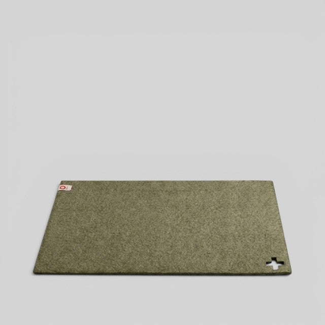 Baabuk khaki felted wool table mat with a small Swiss cross cutout detail on a light grey background.