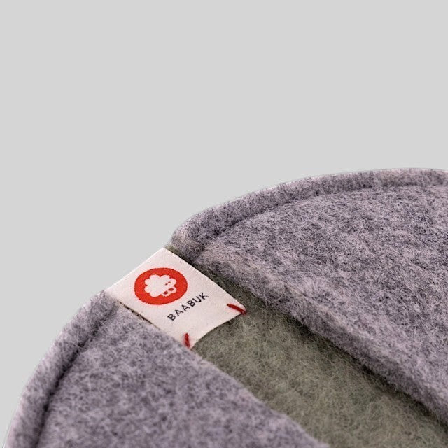 Baabuk khaki felted wool potholder with a branded fabric tag and stitched edge detail