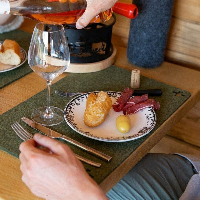 Baabuk khaki felted wool table mat on a wooden dining table with a plate of food and wine glass