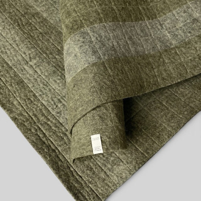 Baabuk khaki felted wool yoga mat with quilted cotton stitching and a soft textured surface