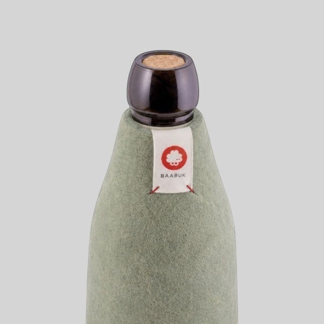 Baabuk khaki wool bottle cover with a cork stopper and a small branded fabric label on a neutral background