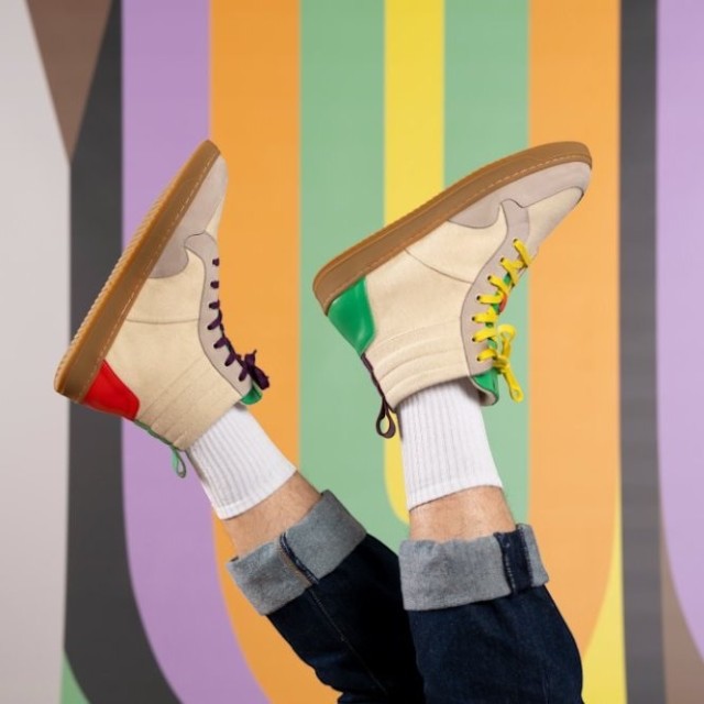 Baabuk Lakeside Wooler sneakers with cream wool, leather accents, and colorful details against a striped background.