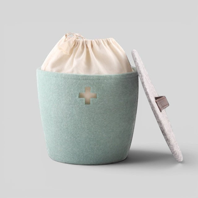 Baabuk small light blue felted wool basket with a Swiss cross cutout, fabric liner, and a matching wool lid.