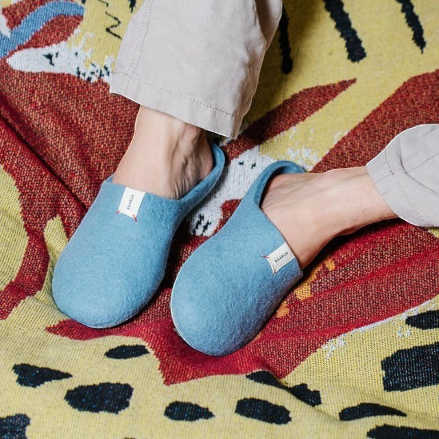 Baabuk light blue wool Kanga slippers worn on a patterned blanket