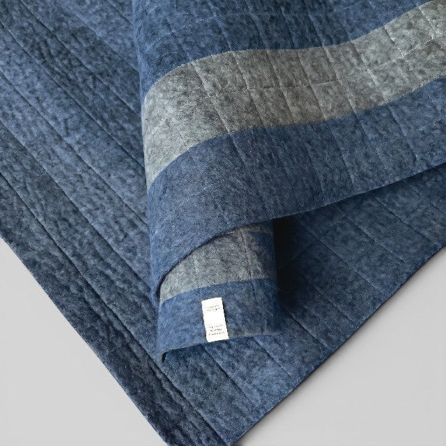 Baabuk light blue felted wool yoga mat with grey striped detail and quilted cotton stitching