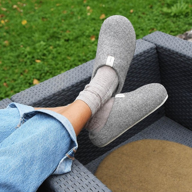 Baabuk light grey handfelted wool slippers with orthopedic cork soles worn outdoors with socks and jeans