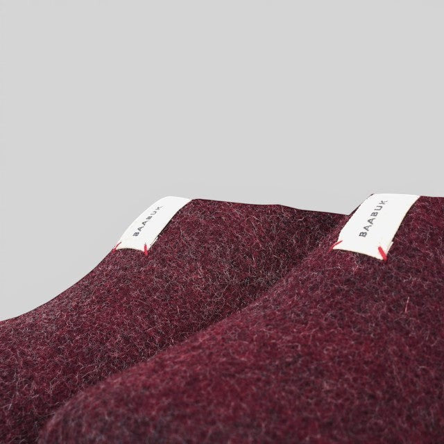 Baabuk Mel slippers in bordeaux wool with white branded pull tabs, handmade in Nepal with natural materials.