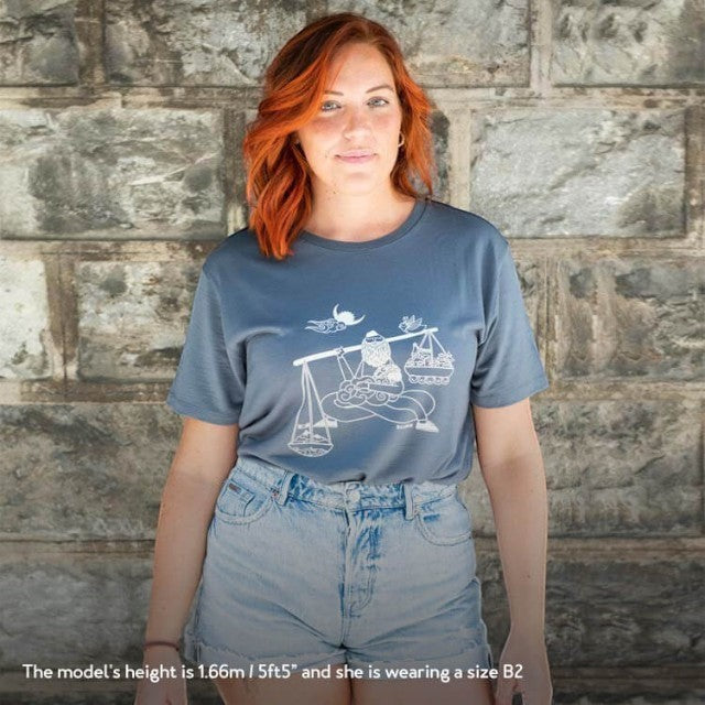 Model wearing a dark grey Baabuk 100% merino wool T-shirt with a white Nepalese-inspired graphic illustration.
