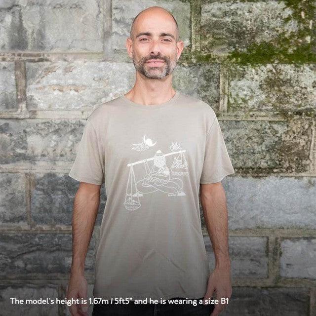 A man wearing a khaki Baabuk 10 Year Anniversary merino wool t-shirt with a white Nepalese-inspired graphic print.