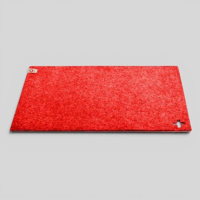 Baabuk Swiss red rectangular felted wool table mat with a small cutout cross detail.