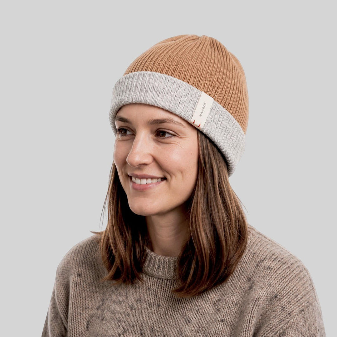 Baabuk reversible camel and grey baby alpaca wool beanie worn by a woman on a white background