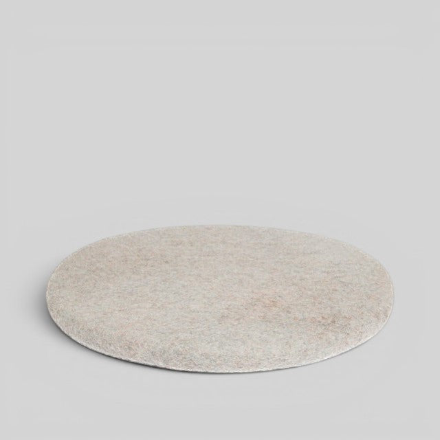 Baabuk handmade round sitting mat crafted from natural New Zealand wool in a neutral beige tone.