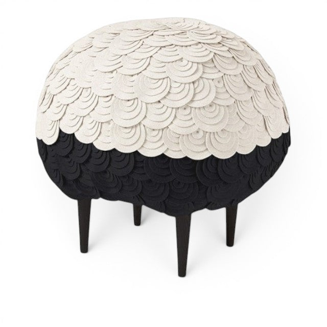 Baabuk Sheep Stool featuring layered white and black wool felt in a rounded sheep shape on dark wooden legs.