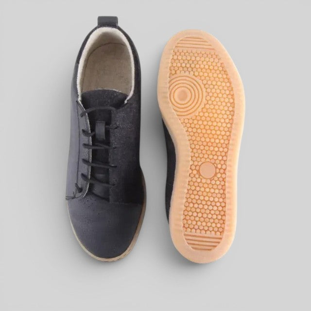 Baabuk Shunya Wooler black sustainable sneakers showing top view and natural rubber sole pattern