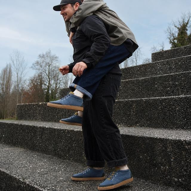 Baabuk Sky Wooler Blue Raisa sneakers with wool upper and rubber sole worn by a man giving a piggyback ride