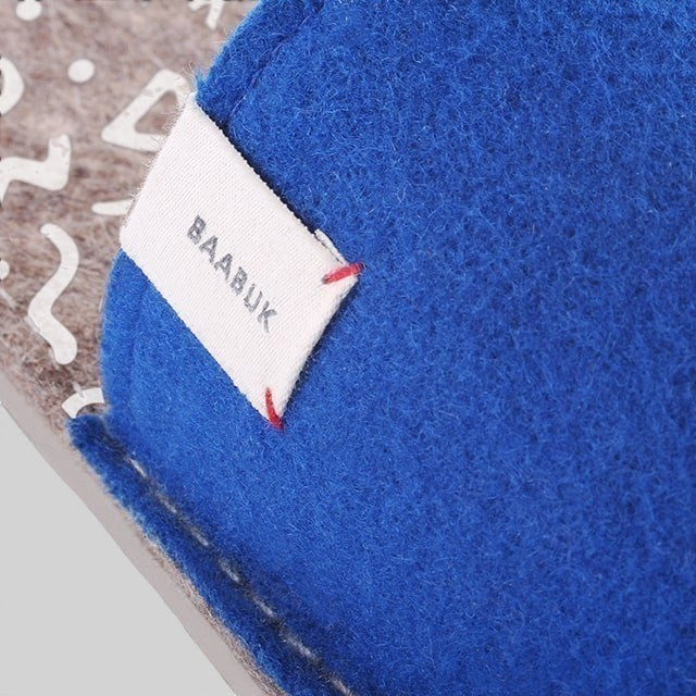 Close-up of Baabuk Baabulette wool sandals in ultra marine blue with a branded fabric label on the side