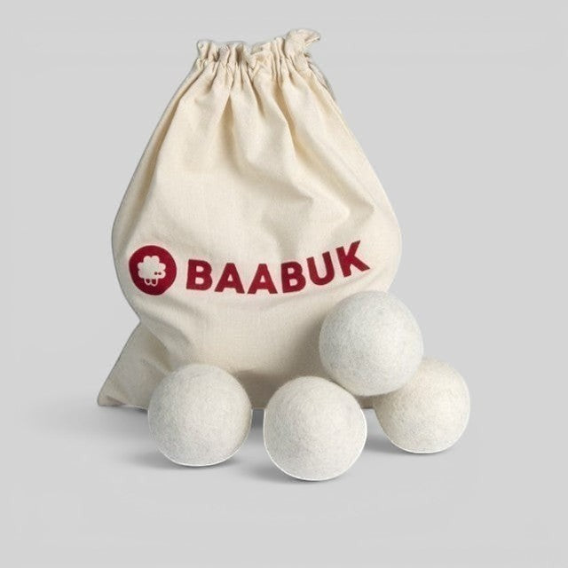 Four white Baabuk wool dryer balls in a branded cotton drawstring carry bag for sustainable laundry care.