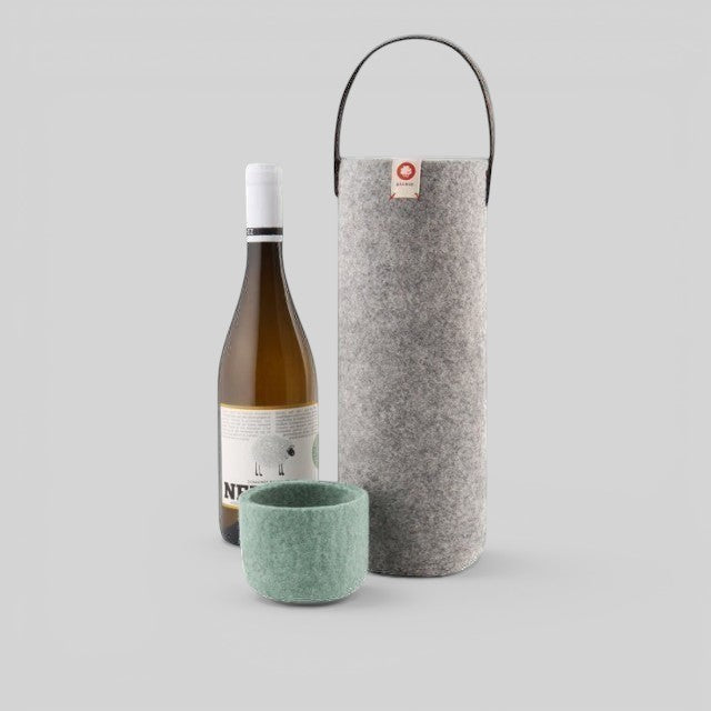Baabuk light grey wool wine cooler with leather strap, shown with a wine bottle and a small matching wool cup.